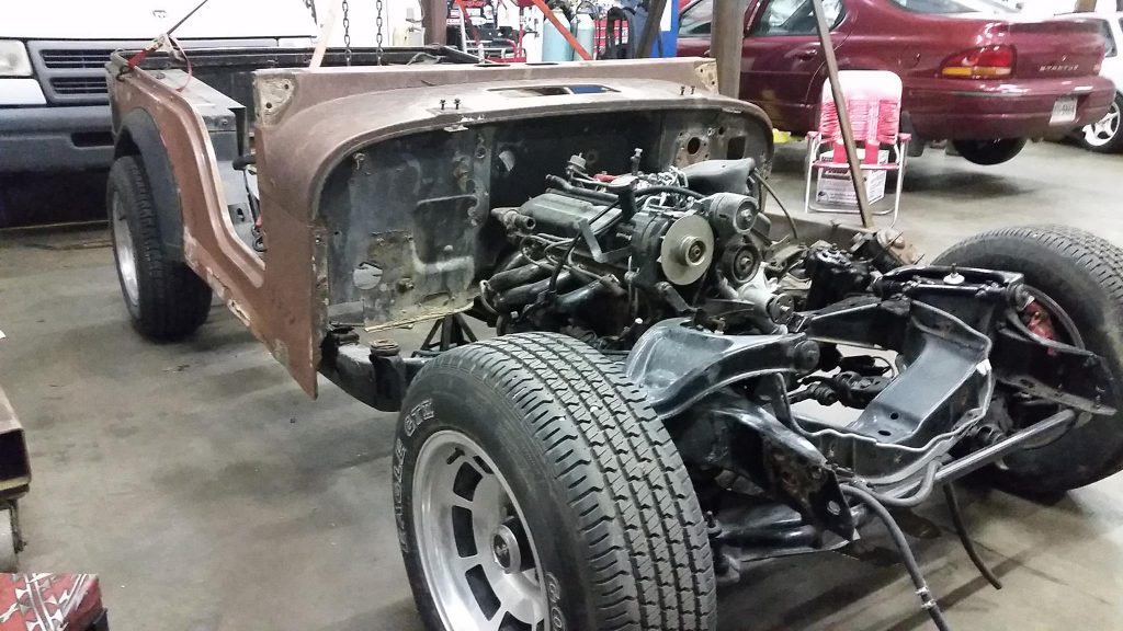 the jeep rat rod body and mustang engine mocked up in the corvette frame